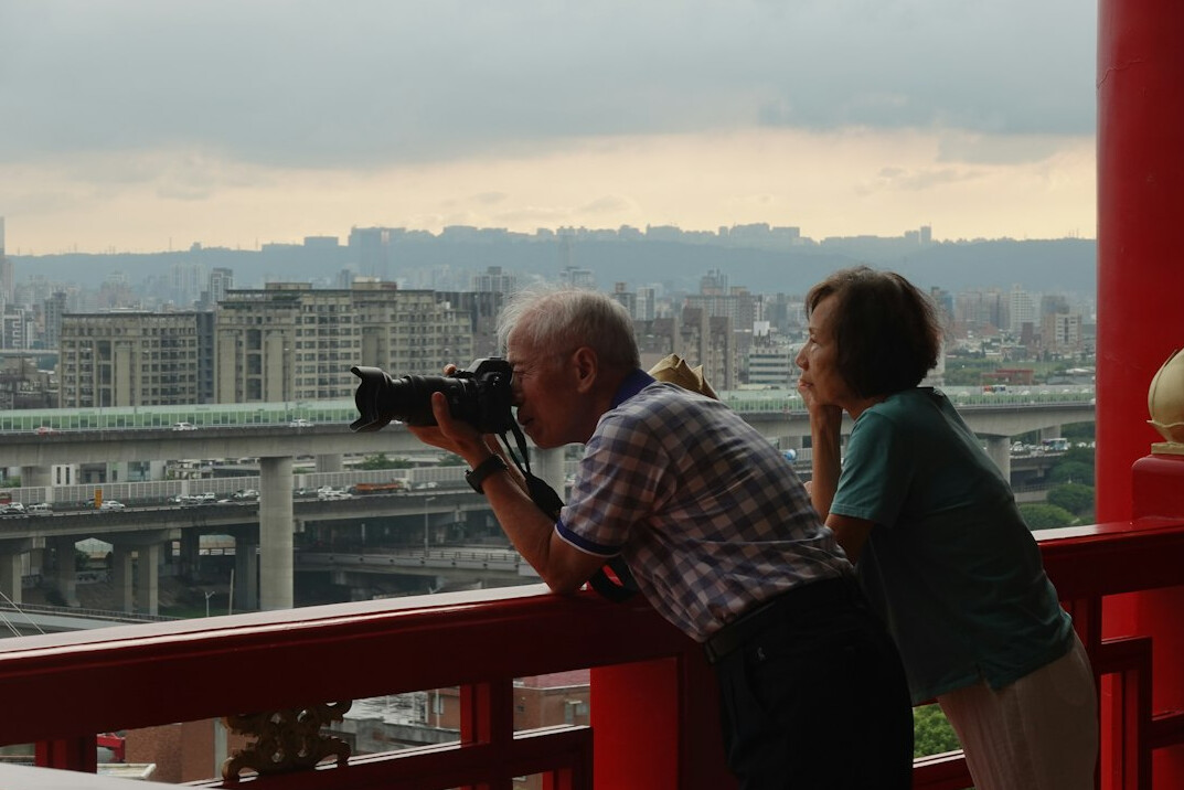 Photographer interviewing an elderly subject with a recorder