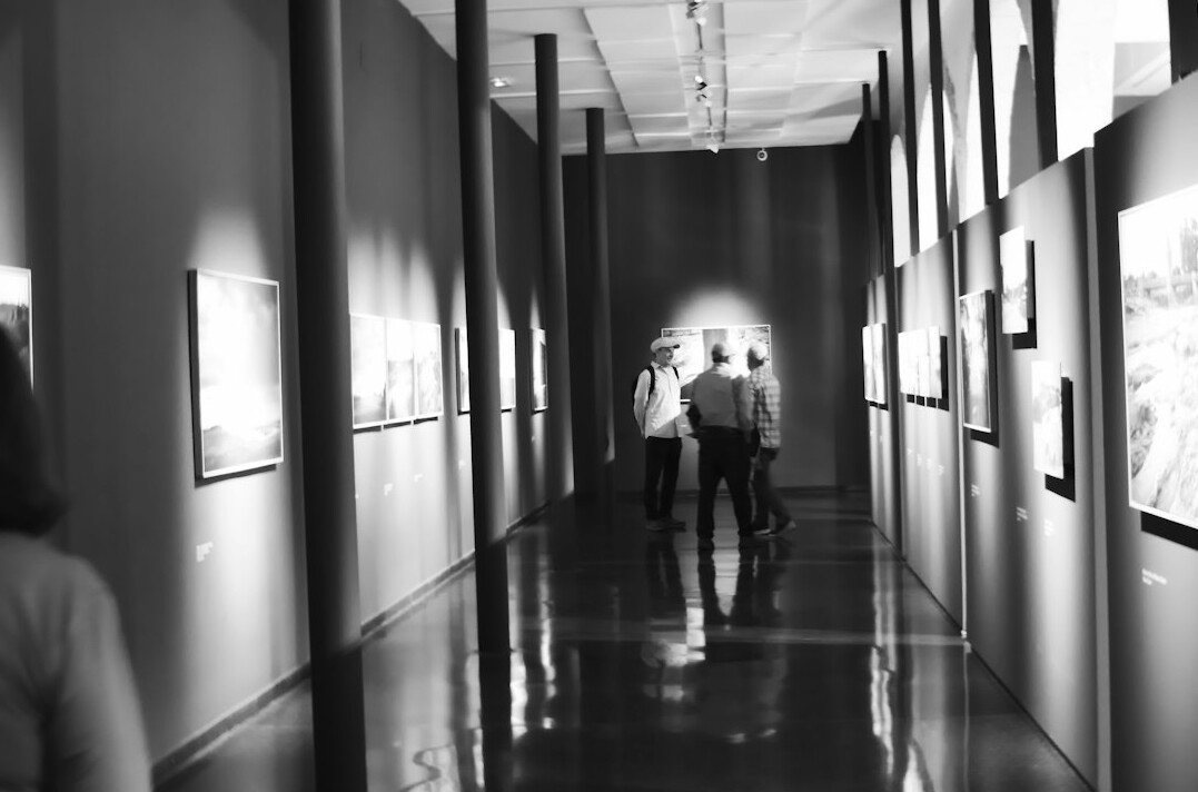 People viewing a photography exhibition on a gallery wall