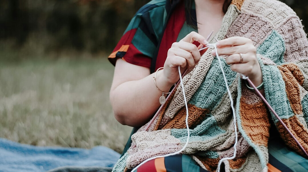 Elderly Danish woman knitting a wool sweater at home