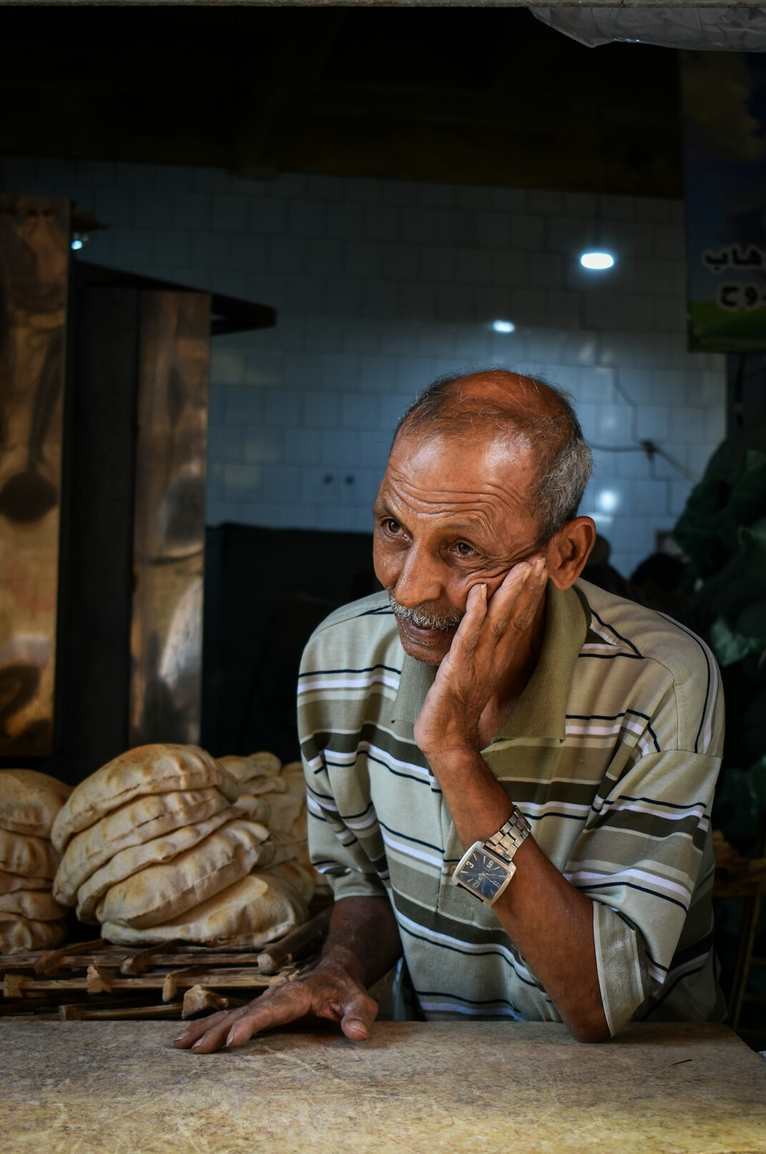 Young Danish baker holding fresh bread in a bakery